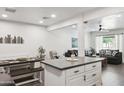 Bright and modern kitchen with white cabinets, gray countertops, stainless appliances, and an open-concept layout to the living area at 3814 N 36Th St, Phoenix, AZ 85018