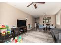 Open-concept living space with dark vinyl floors, ceiling fan, and seamless access to dining area at 5654 W Vineyard Rd, Laveen, AZ 85339