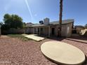 Expansive backyard featuring gravel landscaping with a covered patio space at 6407 W Madras Ln, Glendale, AZ 85306
