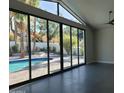 Bright living room featuring tile floors, large glass doors and windows that lead to a sparkling pool at 7724 E Charter Oak Rd, Scottsdale, AZ 85260