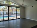 Bright living room featuring tile floors, large glass doors and windows that lead to a sparkling pool at 7724 E Charter Oak Rd, Scottsdale, AZ 85260