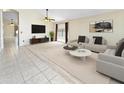 Bright living room with tile floors, a ceiling fan, and modern furniture in a spacious layout at 12770 W Alvarado Rd, Avondale, AZ 85392