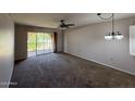 Open living room with neutral carpet and sliding glass doors to the exterior at 131 N Higley Rd # 215, Mesa, AZ 85205