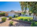 Charming single-story home featuring a well-maintained front yard with mature trees and a two-car garage at 17634 N 34Th Ln, Phoenix, AZ 85053