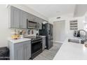 Modern kitchen with grey cabinets, stainless steel appliances, and light countertops. Includes grey backsplash at 17634 N 34Th Ln, Phoenix, AZ 85053