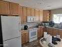 Functional kitchen with wooden cabinets and white appliances, needs renovation at 1843 S Papago Dr, Apache Junction, AZ 85120