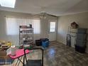 Open-concept living room featuring tile floors, a ceiling fan, and a sliding glass door at 1843 S Papago Dr, Apache Junction, AZ 85120