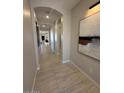 Long hallway featuring an archway and light grey walls at 18941 W Monterosa St, Litchfield Park, AZ 85340
