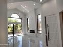 Bright living room with fireplace, high ceiling, tile floors and large windows overlooking the patio at 25150 N Windy Walk Dr # 14, Scottsdale, AZ 85255