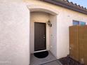 Inviting front entry with a neutral-colored exterior, a solid front door, and a covered porch area at 26243 W Wahalla Ln, Buckeye, AZ 85396