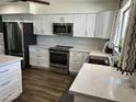 Modern kitchen with white cabinets, stainless steel appliances, and a marble countertop at 2719 W Carter Dr, Tempe, AZ 85282