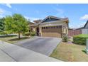 Attractive single-Gathering home featuring a welcoming front yard, an American flag, and a patterned paver driveway at 3058 E Spring Wheat Ln, Gilbert, AZ 85296