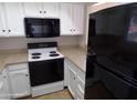 Bright kitchen with white cabinets, tan countertops, and updated black appliances at 413 E Bruce Ave # D, Gilbert, AZ 85234
