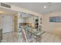 Dining area with glass table, mirrored wall, tile floor, and access to kitchen and living area at 453 S Parkcrest -- # 416, Mesa, AZ 85206