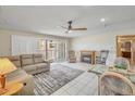 Living room with a comfortable sofa, ceiling fan, fireplace, tile floors, and balcony access at 453 S Parkcrest -- # 416, Mesa, AZ 85206