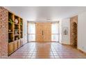 Spacious foyer features Saltillo tile flooring, exposed brick, and custom built-in shelving at 5112 N 32Nd Pl, Phoenix, AZ 85018
