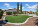 Charming front yard featuring a grassy area, desert landscaping, and mature trees at 5320 W Soft Wind Dr, Glendale, AZ 85310