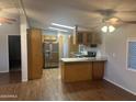 Open floor plan with a kitchen featuring stainless steel appliances, wood cabinets, and granite countertops at 5933 E Main St # 1, Mesa, AZ 85206