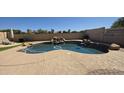 Backyard pool with a charming rock waterfall and easy access to outdoor relaxation areas at 1075 E Crimm Rd, San Tan Valley, AZ 85143