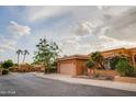 Charming house with a two-car garage, desert landscaping, and palm trees on a sunny day at 10830 N 11Th St, Phoenix, AZ 85020