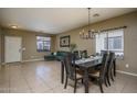 Inviting dining room area with elegant chandelier, large windows, and view of the living room at 11832 W Electra Ln, Sun City, AZ 85373