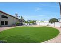 Lush green backyard, surrounded by desert landscaping and privacy fence, offers a serene retreat for outdoor enjoyment at 12222 N 74Th St, Scottsdale, AZ 85260