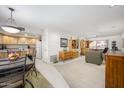 Inviting living room and kitchen area with neutral tones, light-colored cabinets, and access to a private balcony at 12222 N Paradise Village S Pkwy # 220, Phoenix, AZ 85032