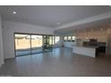 Spacious living room with hardwood floors, large sliding glass doors, and an open layout at 12323 W Luxton Ln, Avondale, AZ 85323