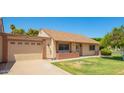 Single-story home with attached garage, lawn, and brick accents under a clear blue sky at 160 Leisure World -- # 160, Mesa, AZ 85206
