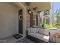 Inviting front porch with seating, stone accents, decorative lantern, and wood shutters at 1713 E Bridgeport Pkwy, Gilbert, AZ 85295