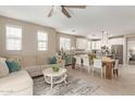 Open concept living room with a large sectional couch, dining table, and white kitchen at 1713 E Bridgeport Pkwy, Gilbert, AZ 85295