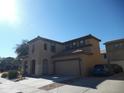 Two-story house with Spanish-style influences, three-car garage, and low-maintenance landscaping at 18548 W Sunbelt Dr, Surprise, AZ 85374