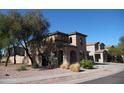 Two-story home featuring arched entry, desert landscaping, and a Spanish-tile roof at 18548 W Sunbelt Dr, Surprise, AZ 85374