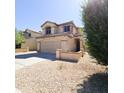 Tan stucco two-story home with desert landscaping, tile roof, and charming front entrance at 1902 N 106Th Ave, Avondale, AZ 85392