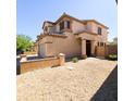 Tan stucco two-story home with desert landscaping, tile roof, and charming front entrance at 1902 N 106Th Ave, Avondale, AZ 85392