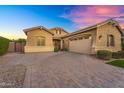 Well-maintained stucco home features a spacious three-car garage and a patterned brick driveway at 20269 E Hummingbird Dr, Queen Creek, AZ 85142