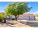 Charming house with a large tree in the front yard and a spacious three-car garage at 21 E Irvine Rd, Phoenix, AZ 85086