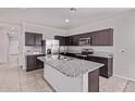 Modern kitchen with granite countertops, stainless steel appliances, and a kitchen island at 28512 N Geode Dr, San Tan Valley, AZ 85143
