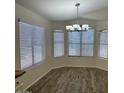 Dining area with wood floors, large windows, and modern chandelier at 4632 E Melinda Ln, Phoenix, AZ 85050