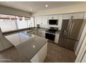 The kitchen features stainless steel appliances, ample counter space, and modern white cabinetry at 4849 W Northern Ave, Glendale, AZ 85301