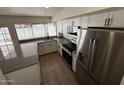 Updated kitchen with new stainless appliances, white cabinets, and grey countertops at 4849 W Northern Ave, Glendale, AZ 85301
