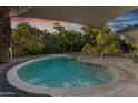 Relaxing pool features pebble accents and shaded outdoor lounging area at 7030 E Orange Blossom Ln, Paradise Valley, AZ 85253