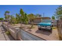View of the home's front yard, featuring mature trees and a charming fence at 705 S Pima --, Mesa, AZ 85210