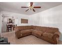 Spacious living room with tiled floors, featuring a large sectional sofa and a ceiling fan at 705 S Pima --, Mesa, AZ 85210