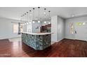 The kitchen island features stone accents, pendant lights, and a functional breakfast bar at 7911 E Posada Ave, Mesa, AZ 85212