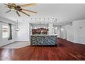 Open-concept living space with hardwood floors, view of kitchen island, and modern lighting at 7911 E Posada Ave, Mesa, AZ 85212