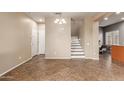 Open-concept living area featuring tile floors, a staircase, and plenty of natural light at 8468 W Lewis Ave, Phoenix, AZ 85037