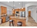 Open kitchen featuring stainless steel appliances, granite countertops and a central island with seating at 8820 W Glenn Dr, Glendale, AZ 85305
