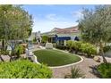 Landscaped backyard featuring a grassy area, mature trees, a pool, and a patio with retractable awnings at 11439 E Bella Vista St, Scottsdale, AZ 85259