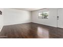 Bright living room featuring dark laminate flooring, a large window, and fresh paint, creating a modern, inviting space at 1234 N 84Th Pl, Scottsdale, AZ 85257